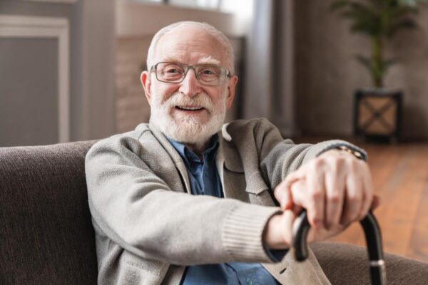 older man smiling with cane after learning tips for managing life with parkinsons disease