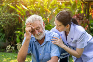caretaker and older man outdoors while discussing advances in parkinson's research