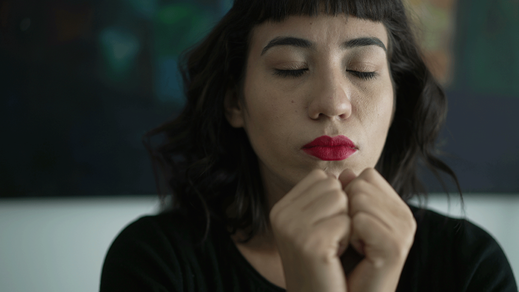 person with eyes closed practicing breathing exercises for anxiety