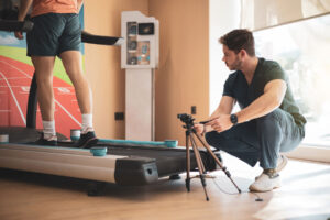 person walking on treadmill while professional captures a video for gait analysis in louisiana